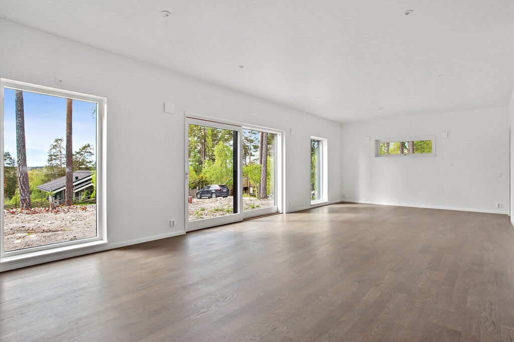 Stor öppen vardagsrumsdel av ett oinrett hus