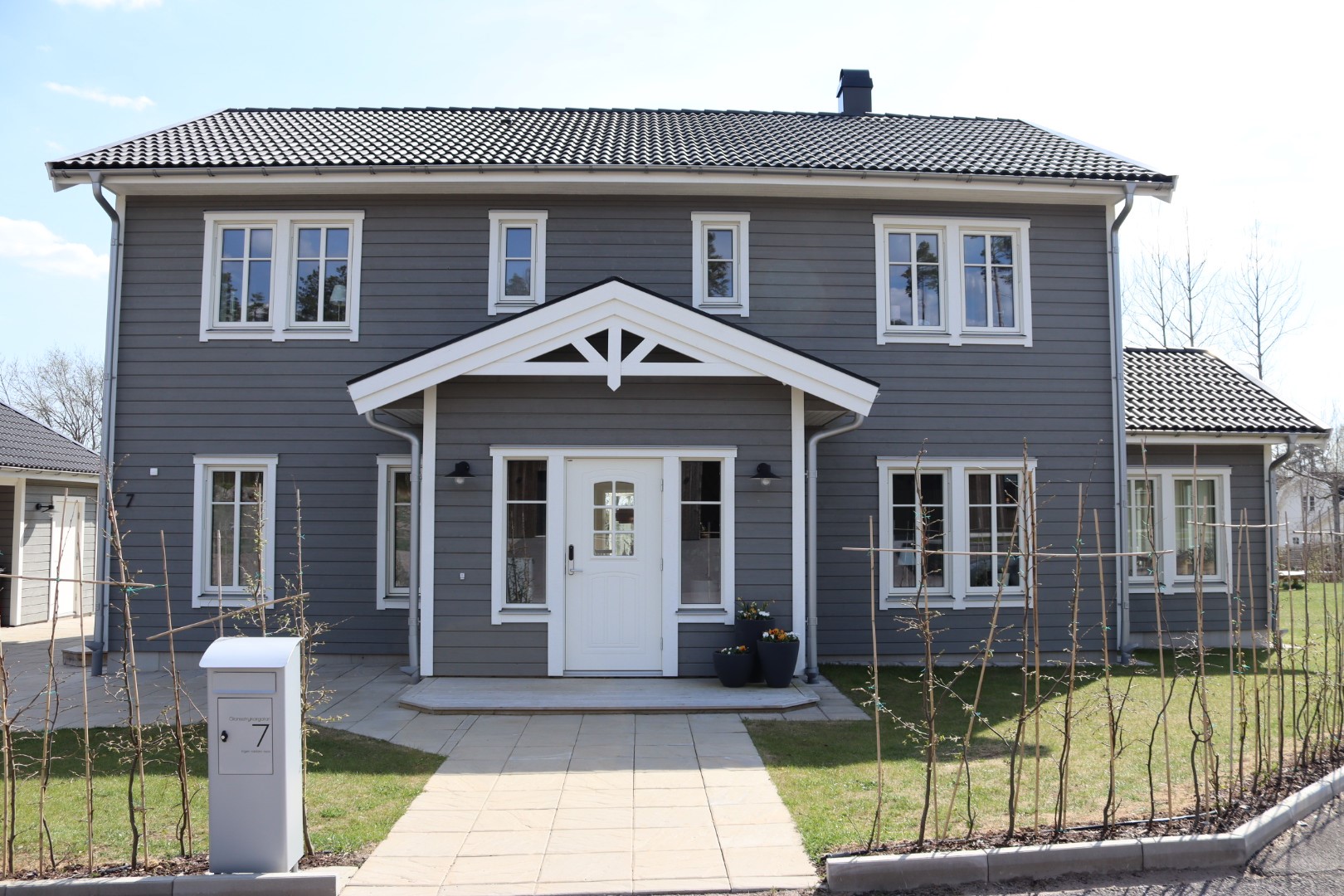 Grått trähus i två plan, från framsidan